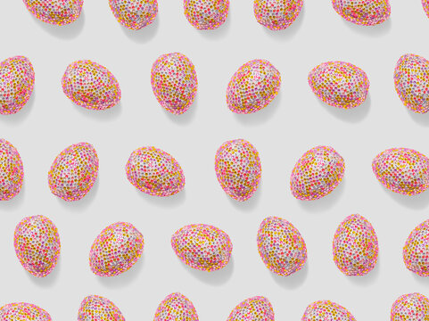 Decorative pink easter eggs in colorful sequins as minimal trend repeat pattern ol light gray. Pop art still life photo of sparkling rhinestones pink egg, spring easter holiday concept, modern design.