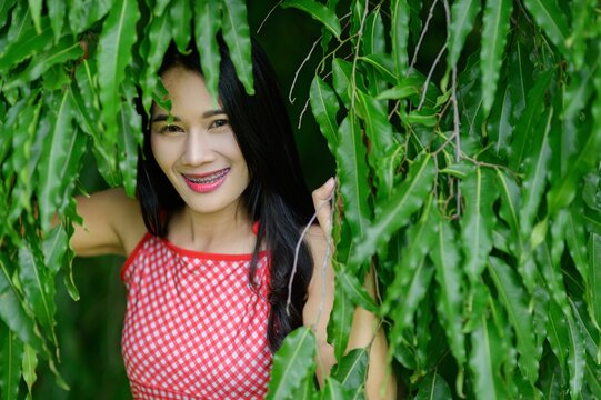 Woman in Red Dress Enjoys Nature in Beautiful Flower Garden
