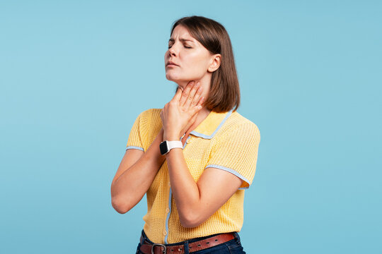 Sad woman suffering from sore throat pain on blue background