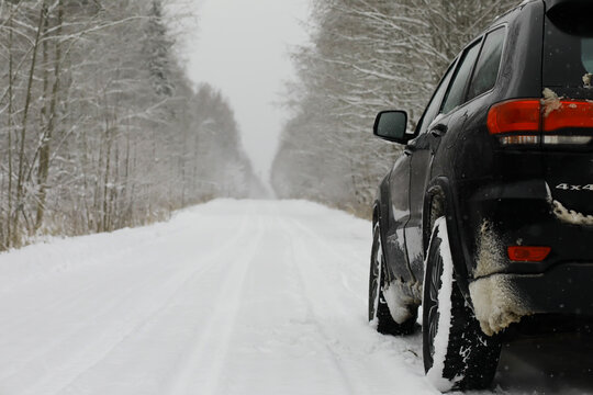 Car in the winter forest. Traveling through a snowy park by car during the Christmas holidays.
