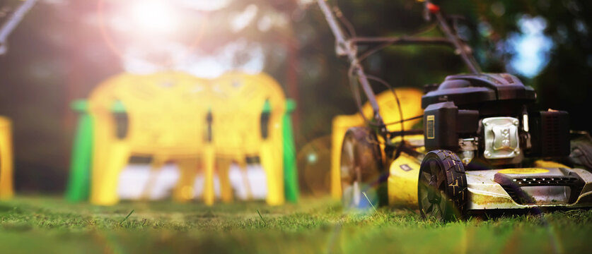 Lawn mower cut grass. Garden work. Electric Rotary lawn mower machine. Panorama, banner