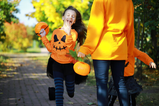 Happy family walk in the park on Halloween. Family dressed up in Halloween costumes