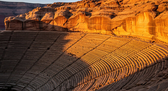 sunrise over canyon with a natural amphitheater of layered rock glowing