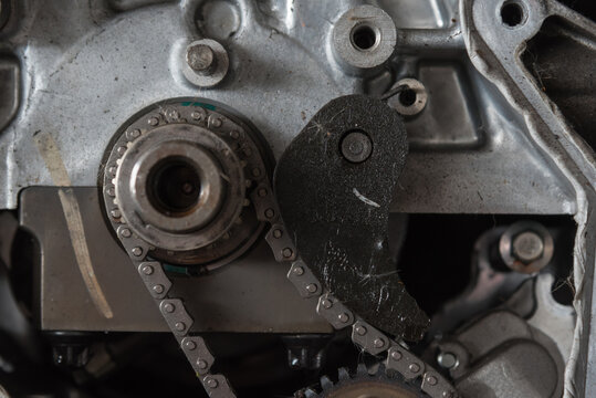 Close up of an automotive timing chain mechanism sprocket metal housing showing internal engine components for repair maintenance engineering