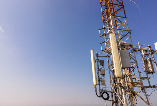 Aerial Scenery of Multiple Radio Masts and Antenna Equipment Installed on a Large Telecommunication Tower Under a Clear Morning Sky. Communication Technology and Network Equipment Viewed from Above.