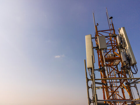 Aerial Scenery of Multiple Radio Masts and Antenna Equipment Installed on a Large Telecommunication Tower Under a Clear Morning Sky. Communication Technology and Network Equipment Viewed from Above.