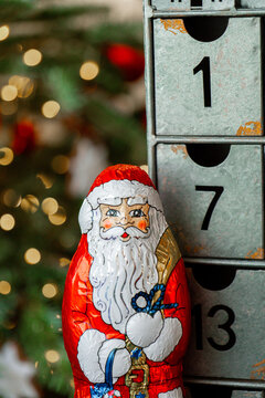 Christmas candy Santa Claus figure. holiday confectionery against numbered drawers of a metal advent calendar for Christmas retail campaigns,seasonal packaging, December gift ideas