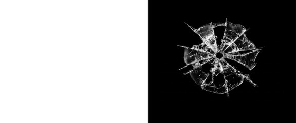 Shattered glass bullet hole on black background, broken window glass texture with radial cracks, realistic bullet impact damage effect © Creative Element