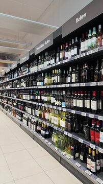Shelves with Austrian and international wines bottles in a supermarket in Austria
