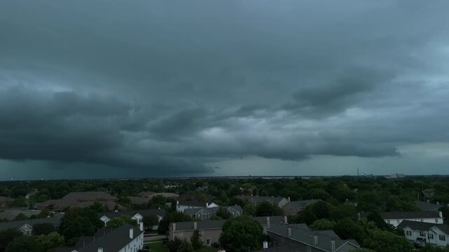 Dark storm clouds forming over the countryside. Darck shelf cloud approaching across open fields with an ominous sky, Wide drone shoot