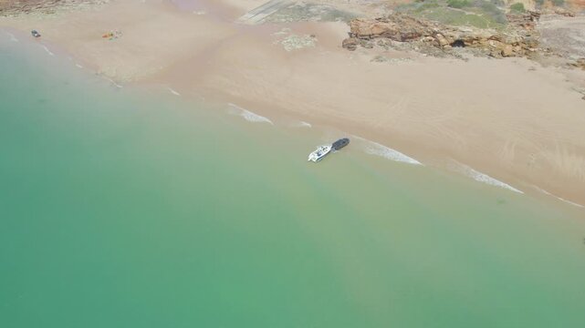 4WD Vehicle Launching Boat from Sandy Beach