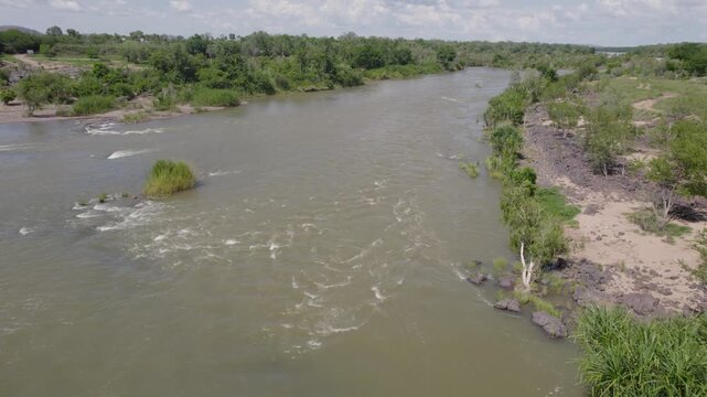 Top View Of Tourists Relaxing On The Rocks With Flowing River