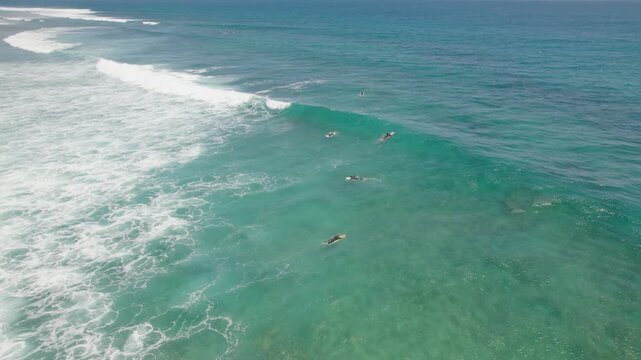 Red Bluff Surfers Riding Turquoise Ocean Waves Over Coral Reef