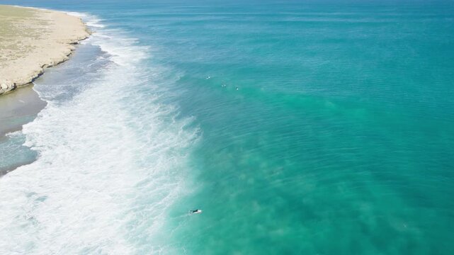 Surfing - Surfers Riding Waves Near The Rocky Shore. - aerial shot