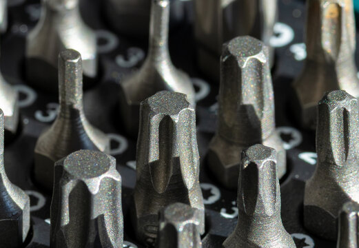 Close-up of a set of star-shaped Torx screwdriver bits arranged in a tool case. An organized screwdriver bit set