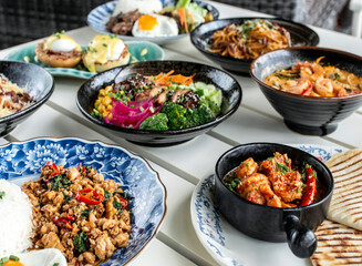 Mixed fusion western and asian lunch food spread on modern outdoor restaurant table
