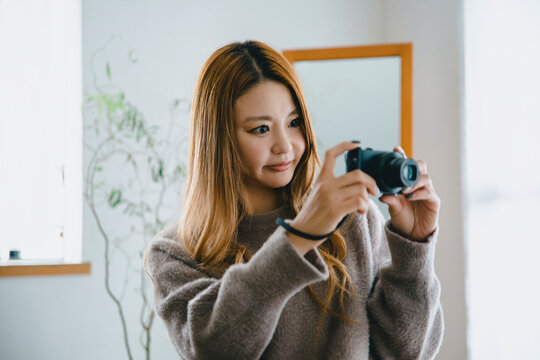 Beautiful Japanese woman taking photos with a digital camera in an autumn and winter setting