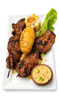 Peruvian anticucho grilled meat skewers with potato and creamy sauce