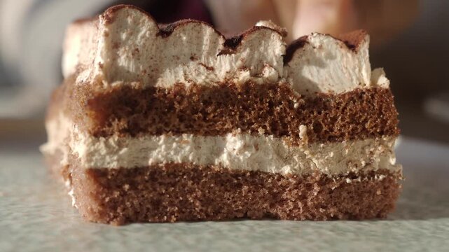Close up slice of tiramisu cake being cut with fork sweet dessert preparation.