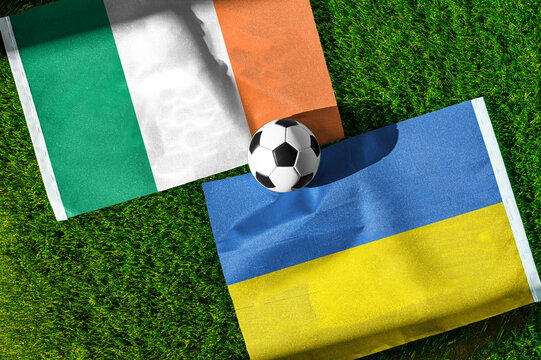 Republic of Ireland vs. Ukraine football match. National flags on green grass with soccer ball in the middle. Football background for international match.