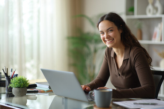 Young telecommuter posing looking at camera at home