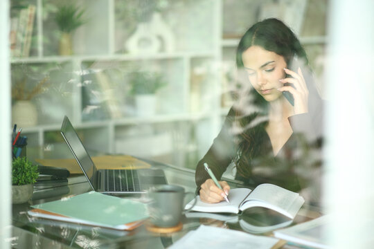 Young telecommuter working attending call and appointing in agenda