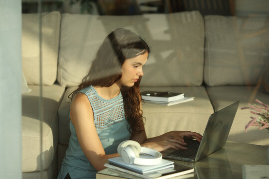 Student typing on laptop e-learning at home
