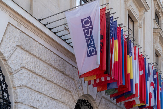 OSCE flag and national flags hanging outside an elegant building facade