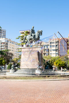 Giant soap bubbles floating in Espolon Square with Espartero monument in Logrono Spain