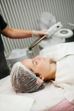 Young woman relaxing during a facial skin treatment procedure