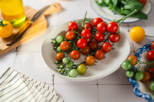 A bowl of fresh colorful cherry tomatoes on a vine