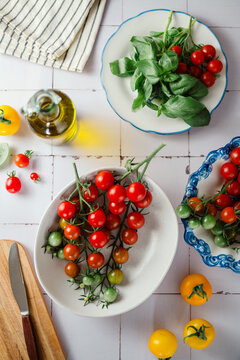 Fresh cherry tomatoes basil and olive oil on a table