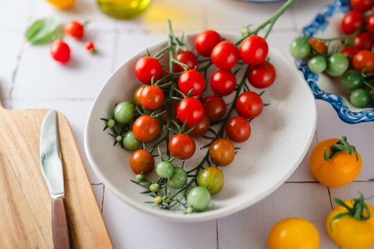 Colorful cherry tomatoes on a bright white kitchen counter
