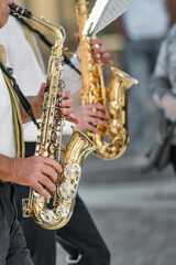 Fototapeta premium Close-up of Musicians Playing Saxophones Outdoors in Casual Setting