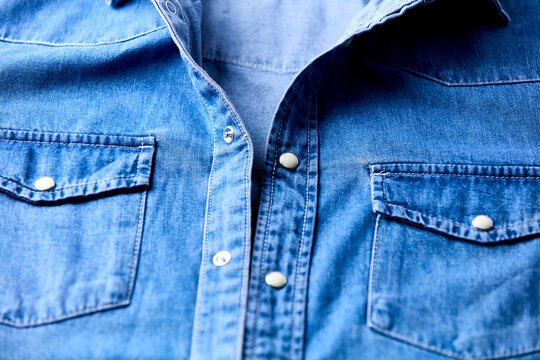 Close up of blue denim shirt with buttons. Soft focus.