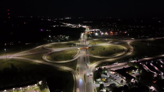 Night drone aerial flying forward over the South Perimeter Highway and Pembina Highway interchange facing south towards St Norbert in Winnipeg, Manitoba, Canada.