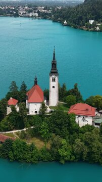 Lake Bled, Slovenia. Vertical Drone Shot of Catholic Church and Tower on Small Island in Turquoise Alpine Water