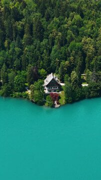Vertical Drone Shot of Lakefront Villa and Landscape by Glacial Blue Water Color of Lake Bled, Slovenia