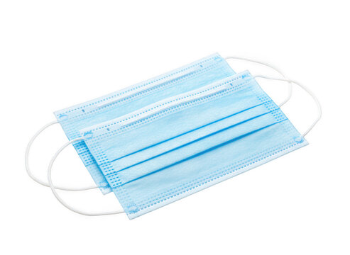 Two blue disposable surgical face masks with white elastic ear loops, stacked on of each other, isolated on a black background isolated on a transparent background