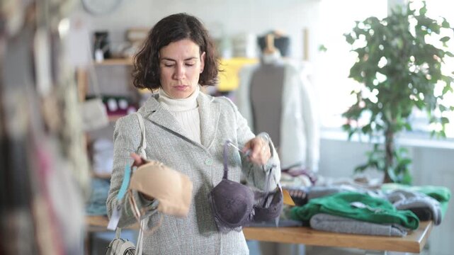 Seasonal trade sale, customer review at products in store and pick out clothes. Latin American woman search and choose bra, purchase some wardrobe items. Style and fashion type look, modern trends. 