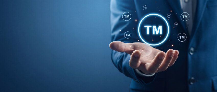 Businessman Holding Glowing TM Digital Trademark Symbol for Intellectual Property Rights Protection and Legal Brand Identity Concept Against a Dark Blue Corporate Background