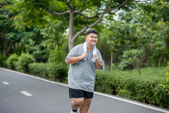 Asian plus-size man exercises outdoors in the garden to lose weight. 