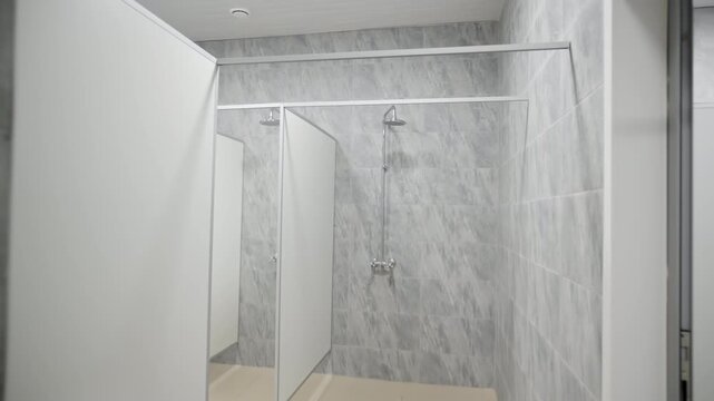 Modern school shower room with clean and carefully arranged shower spaces. Students comfortably wash after demanding training sessions