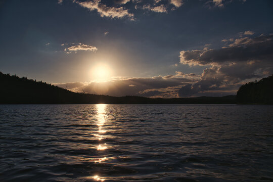 Radiant Sunset Over Calm Lake, in sweden, with Light Reflection.