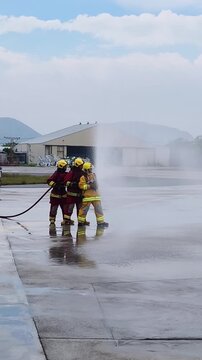 Firefighters are practicing firefighting by spraying water forward.