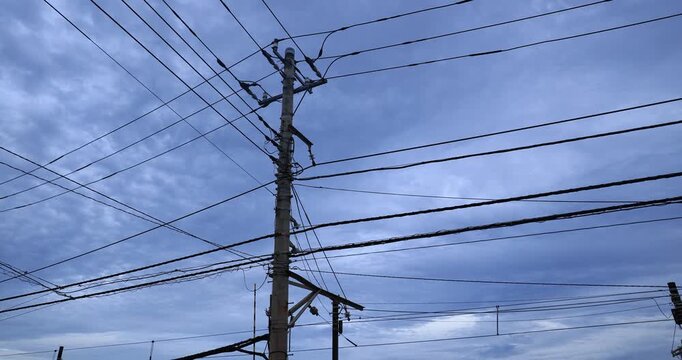  Multiple wires radiate outward against a blue sky in Japan