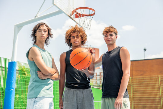 Multicultural friends posing on a basketball court