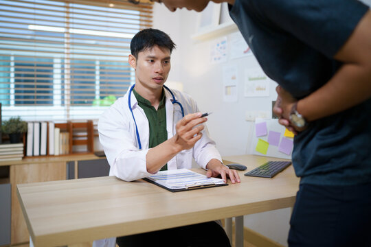 Crohn's disease or ulcerative colitis concept. Doctor counseling male patient with abdominal pain in hospital examination room, ideal for healthcare and medical service
