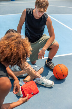 vertical Friends providing first aid to injured player on basketball court