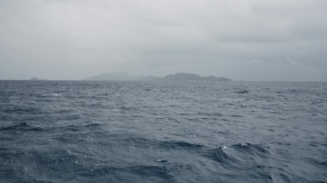 Slow motion sailing on a boat around Seychelles island on a foggy day